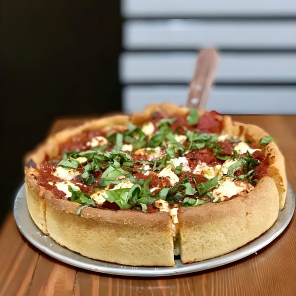 A deep-dish pizza from The Underground Pizza, topped with tomato sauce, cheese, and fresh basil.