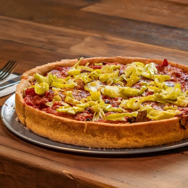 Deep dish pizza from The Underground Pizza, topped with red sauce and bright green banana peppers.